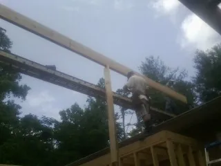 Carpenter setting a ridge beam over a new addition frame — Ice Dam Removal by Roofing Brothers in West Bend