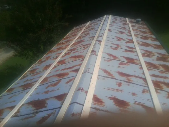 Rusted metal roof panels with new wood purlins before replacement — Storm Damage Roof Repair in West Bend by Roofing Brothers