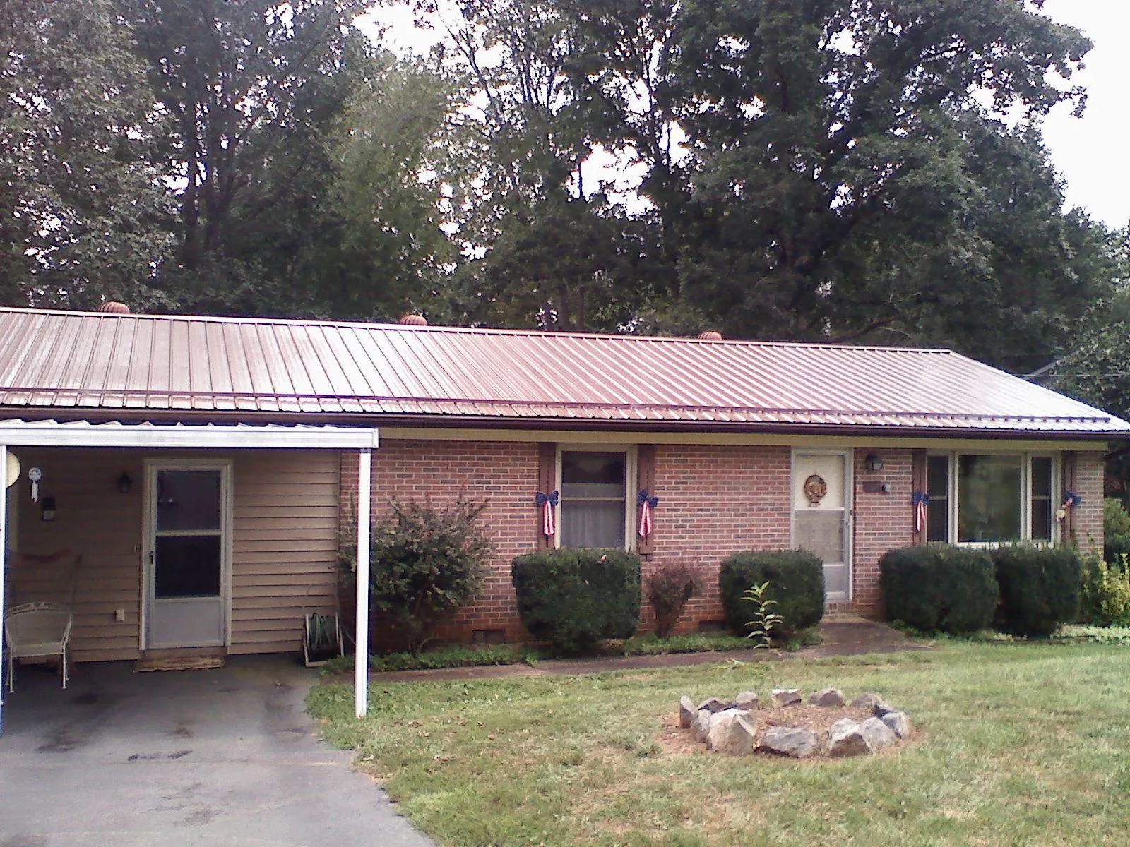 Bronze metal roof and carport on a brick ranch home — Roof Repair work by our crew in West Bend