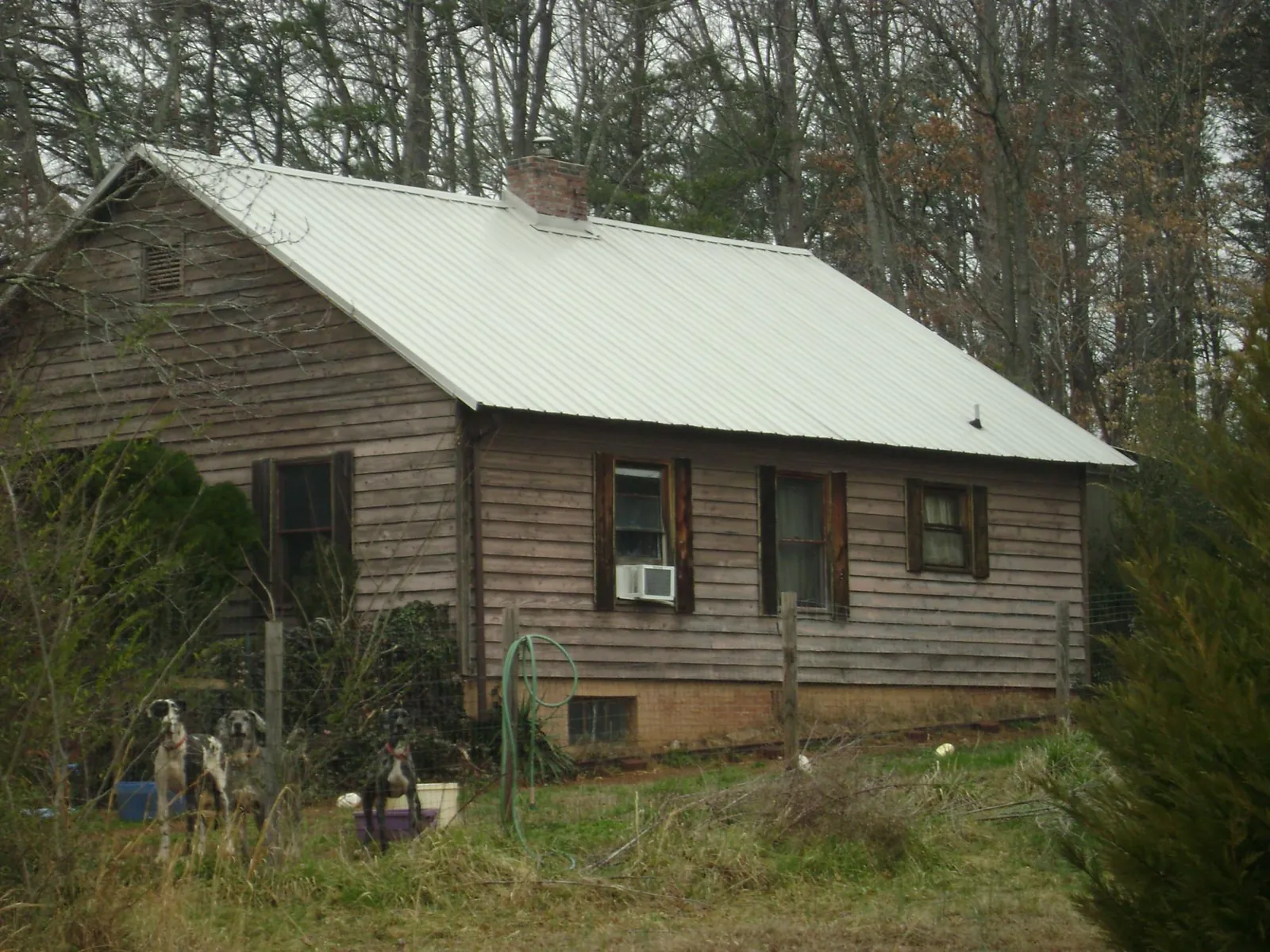 White metal roof on an old wood sided farmhouse, from a Asphalt Shingle Roof Repair job in West Bend